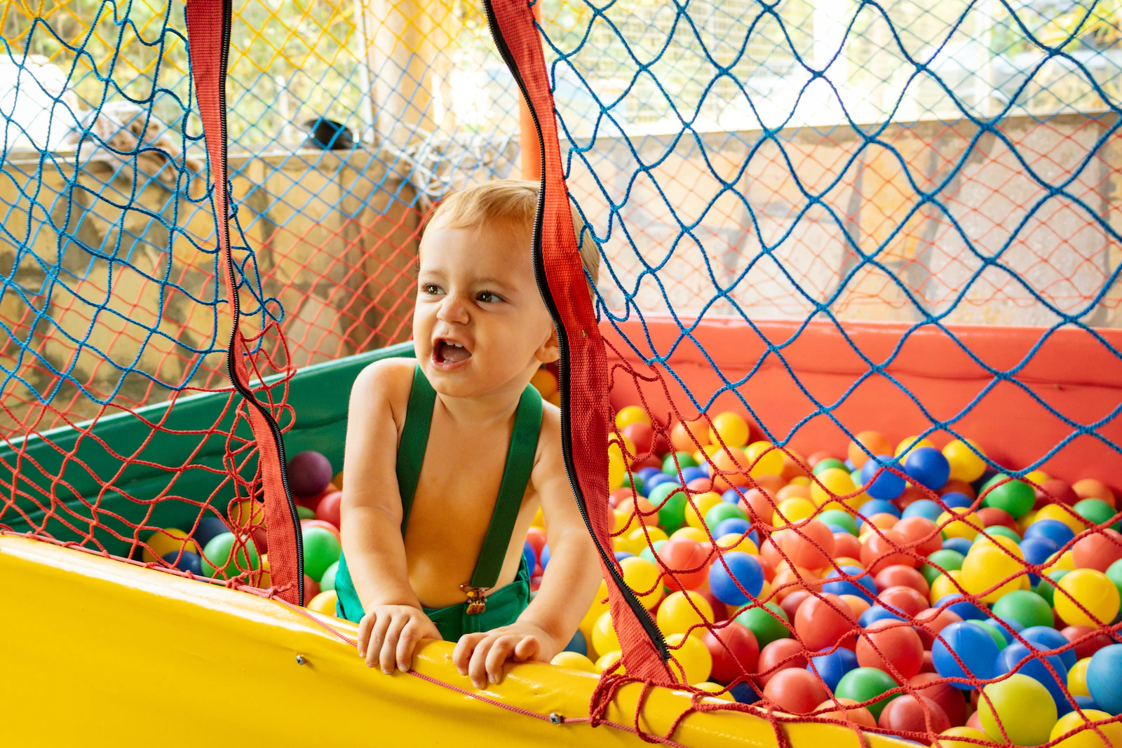 Menino brincando na piscina de bolinhas durante a festa de aniversário
