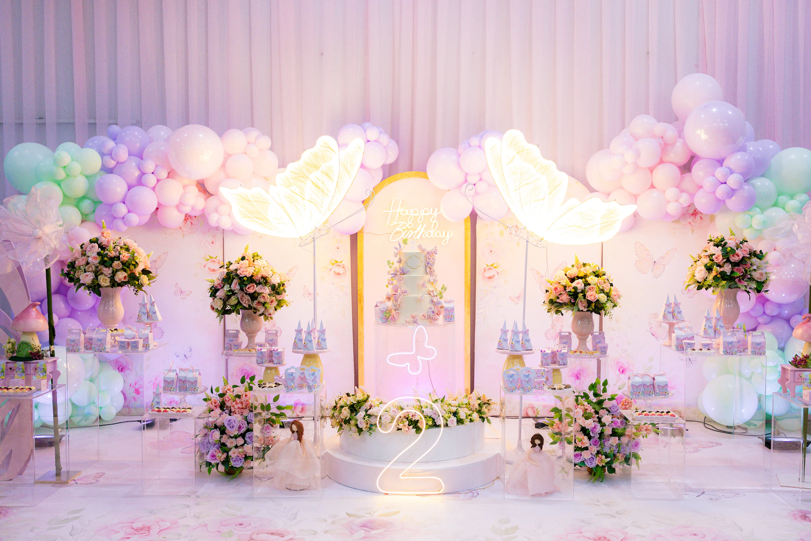 Mesa do bolo iluminada e decoração em tons pastel de festa de aniversário infantil em Goiânia