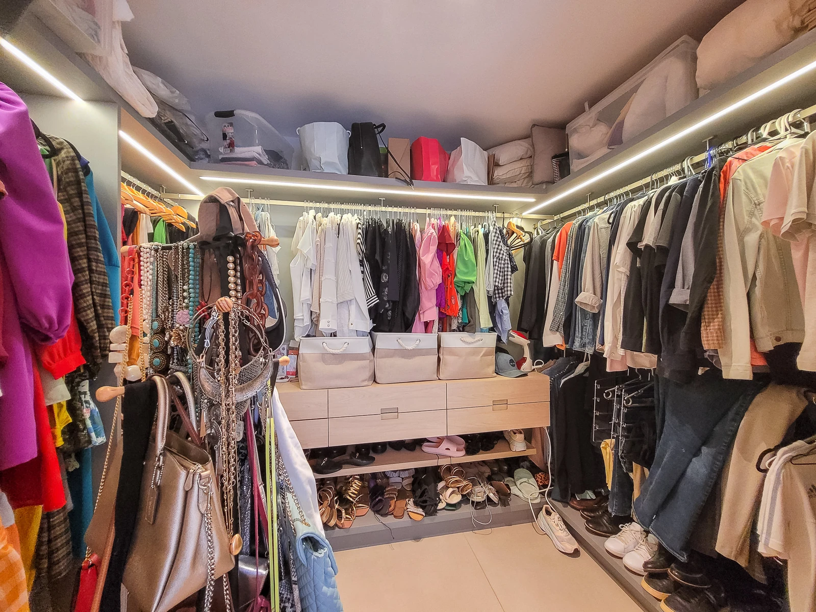 Closet planejado da suíte master, com araras de roupas, sapateira e iluminação em fita de LED