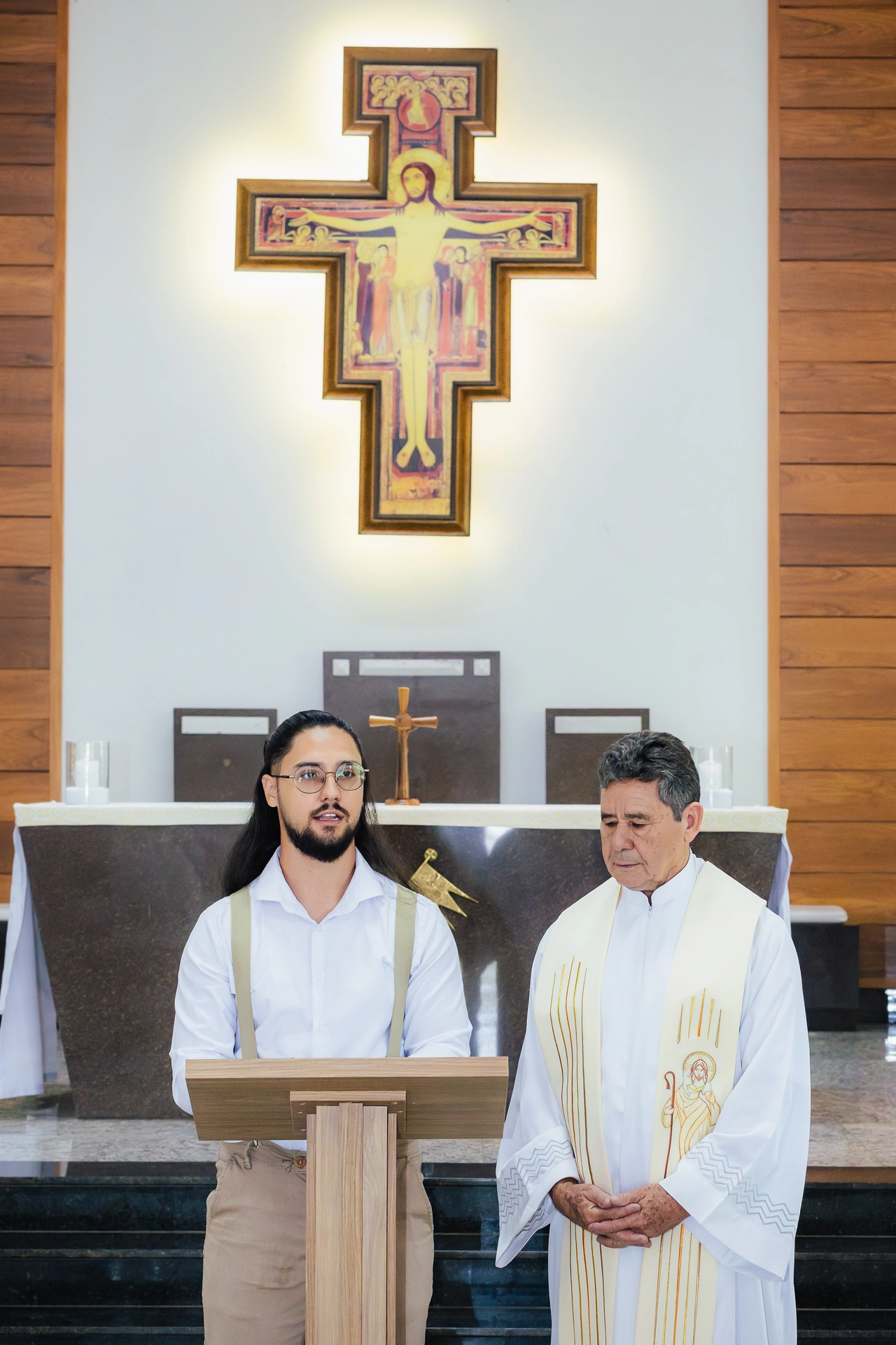 Celebrante e leitor no altar durante a celebração do batizado