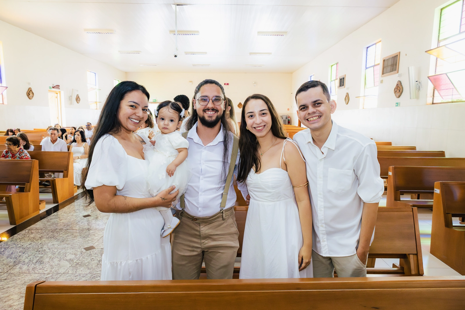 Pais, padrinhos e familiares reunidos após a cerimônia de batizado