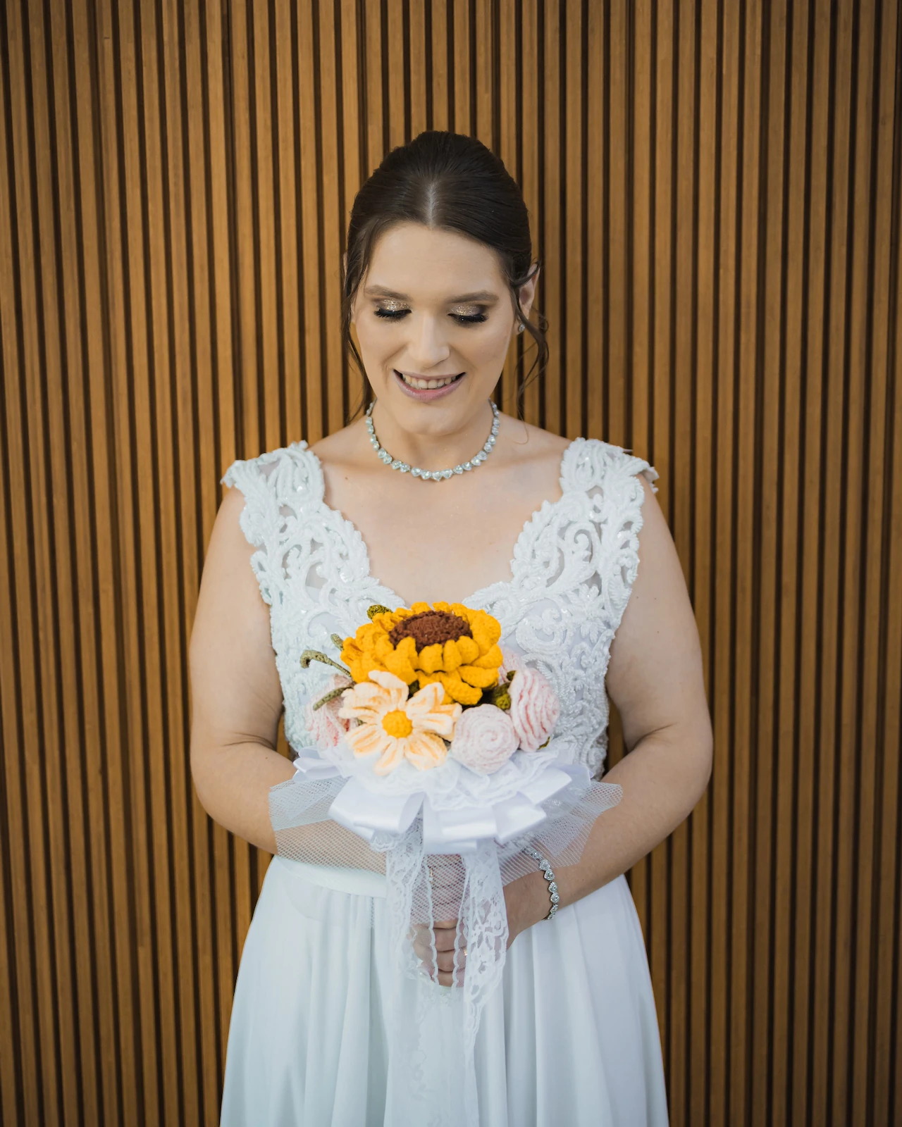 Retrato de Andressa olhando para o buquê de girassóis durante o casamento civil