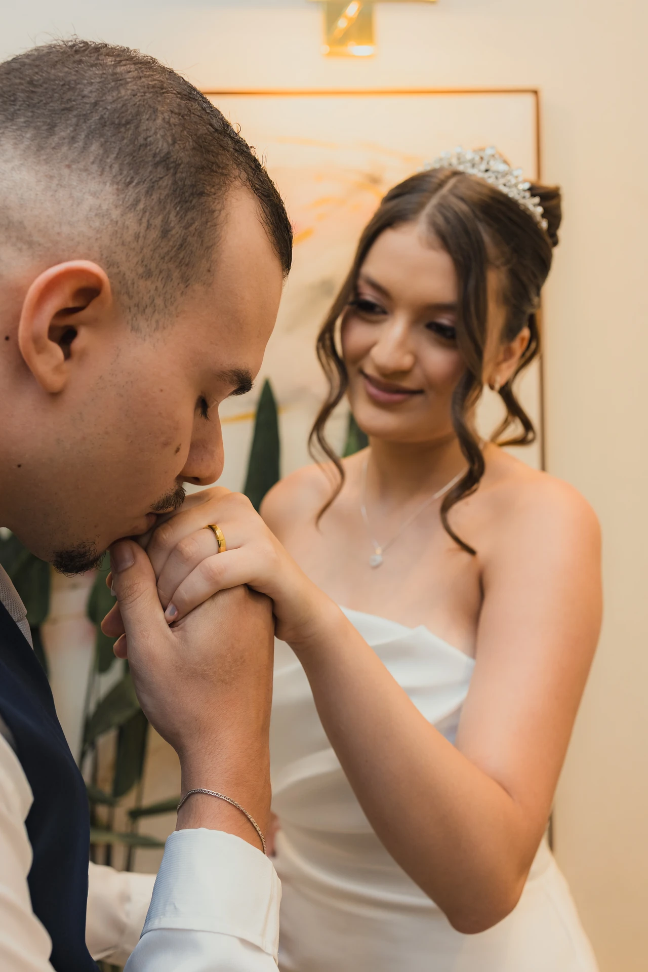 Pedro beijando a mão de Alexya, que sorri, durante o casamento civil