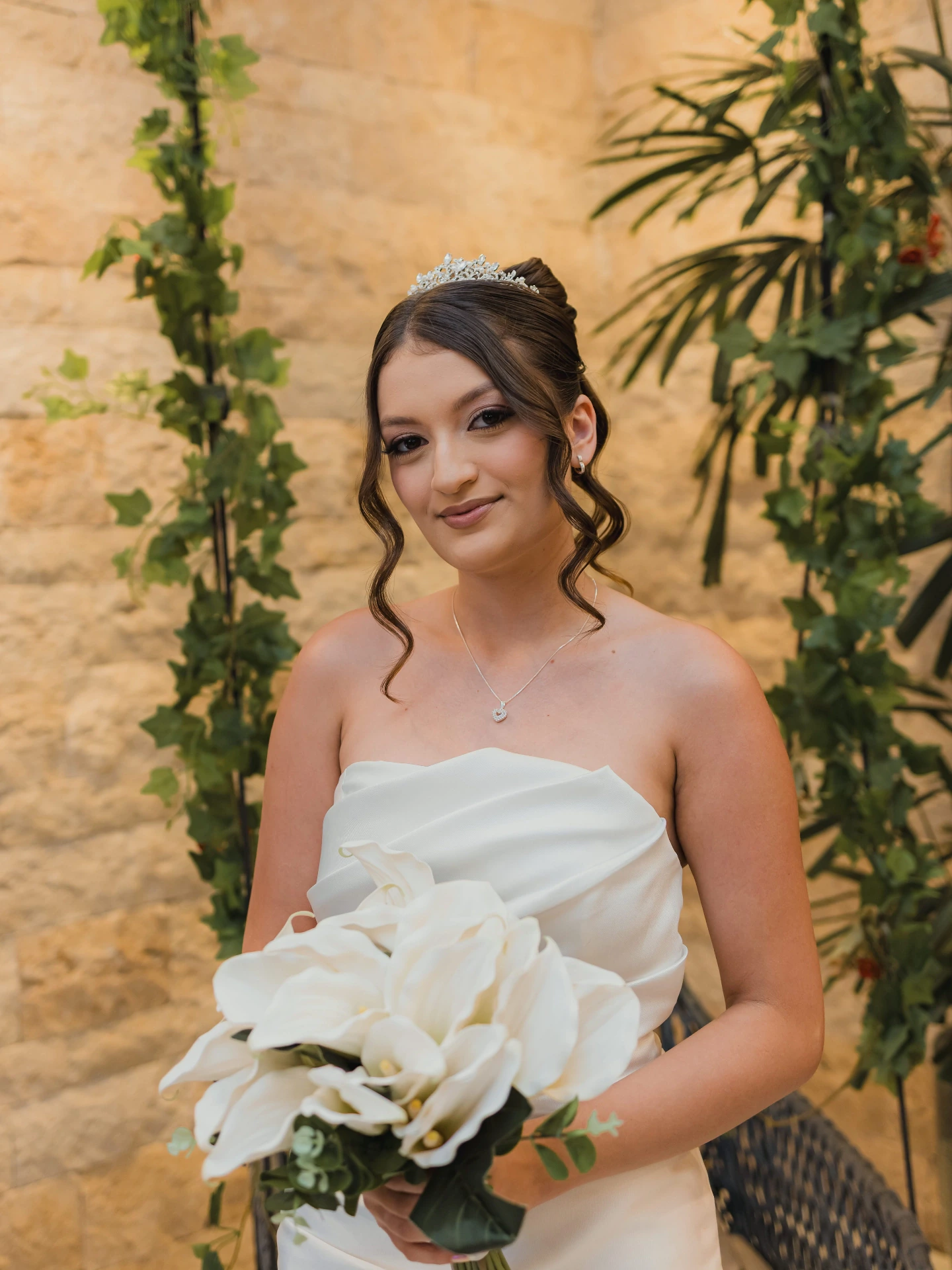 Retrato de Alexya com o buquê de orquídeas brancas, plantas ao fundo
