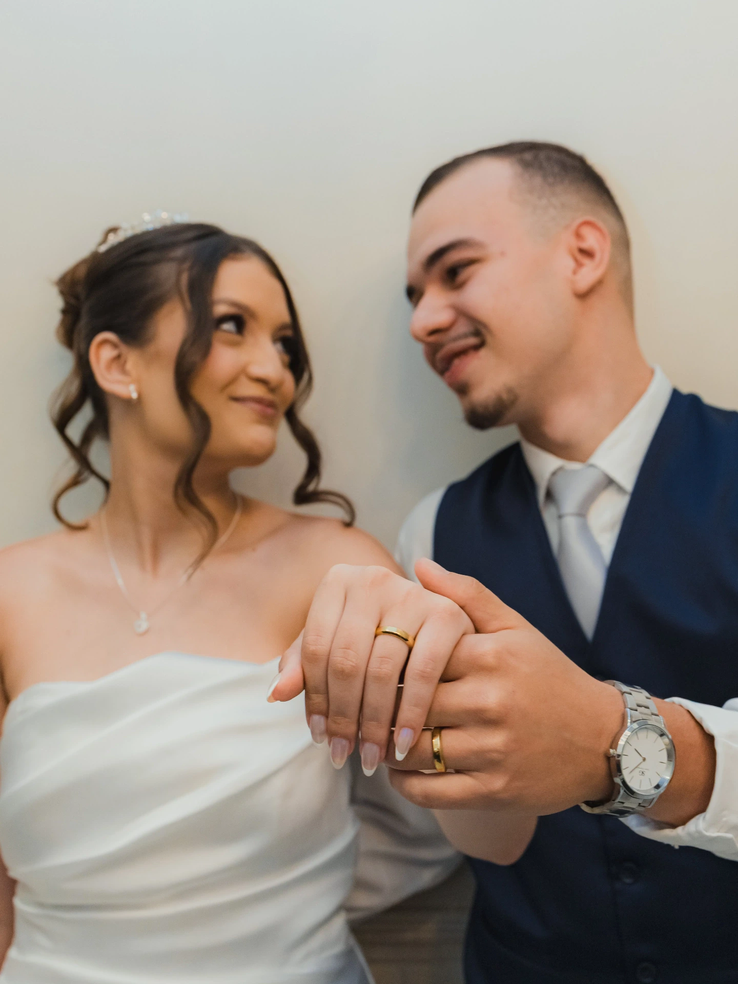Os noivos se olhando e mostrando as alianças durante o casamento civil