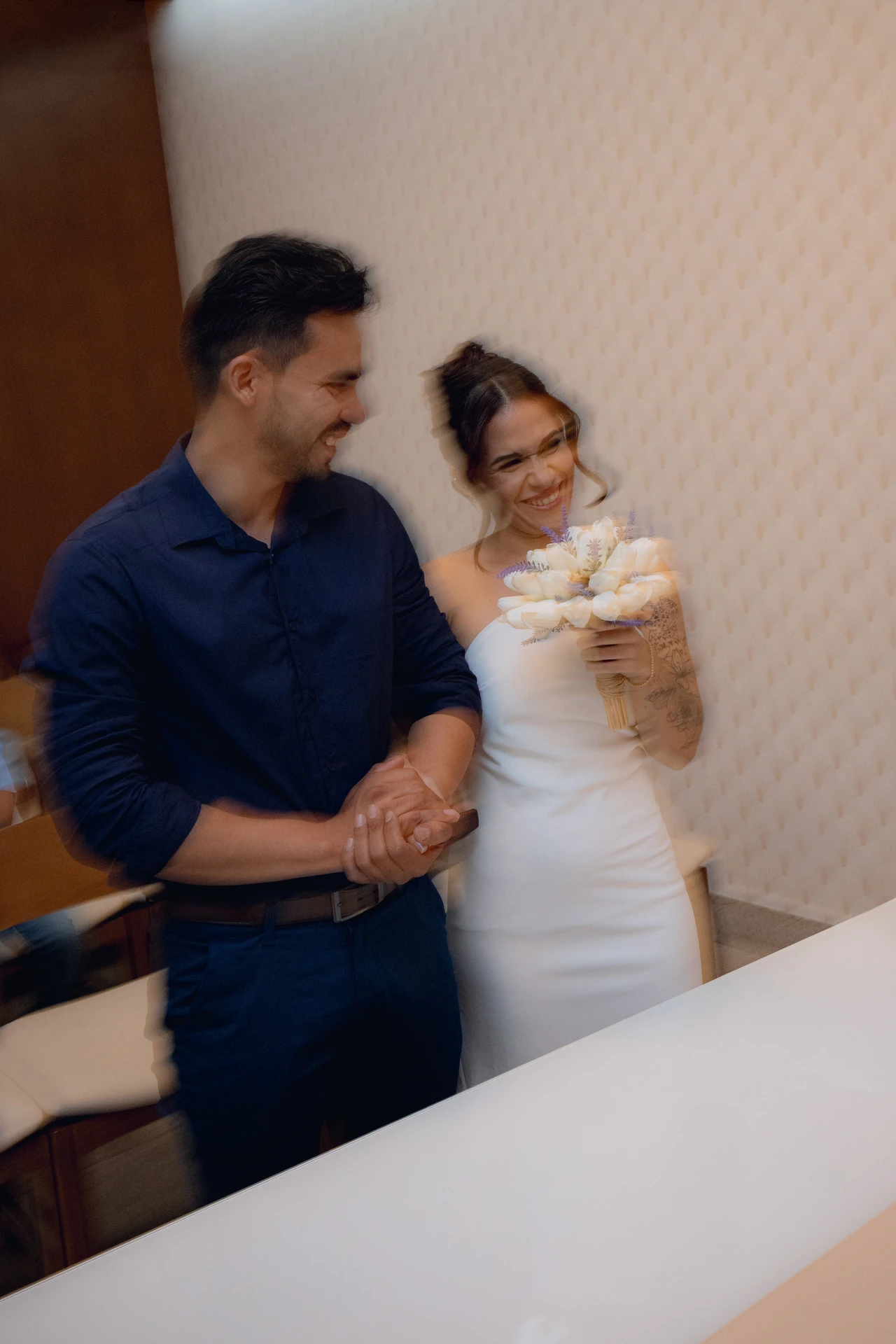 José e Alice rindo juntos, de mãos dadas, em foto com movimento durante a cerimônia