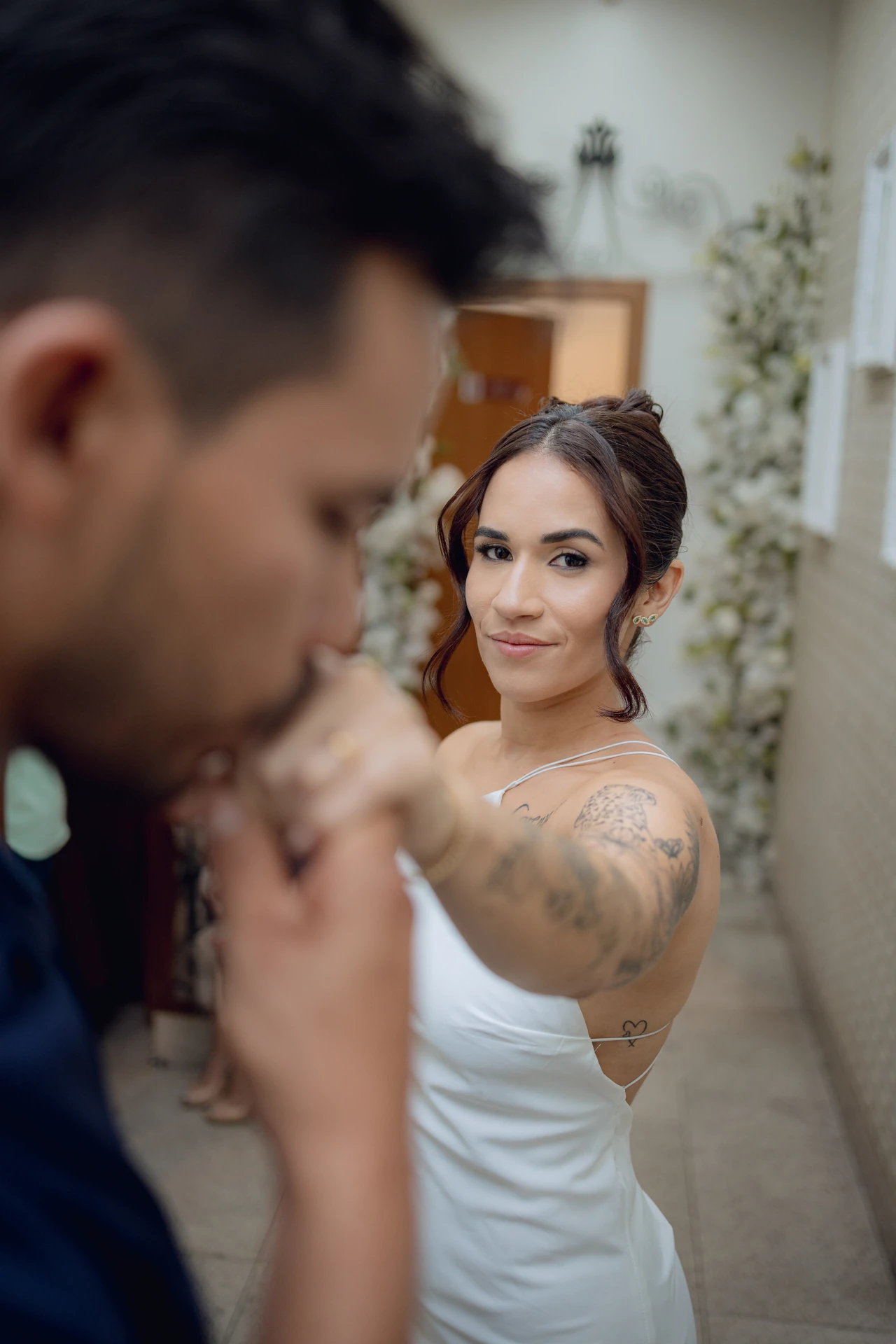 José beijando a mão de Alice enquanto ela olha para a câmera