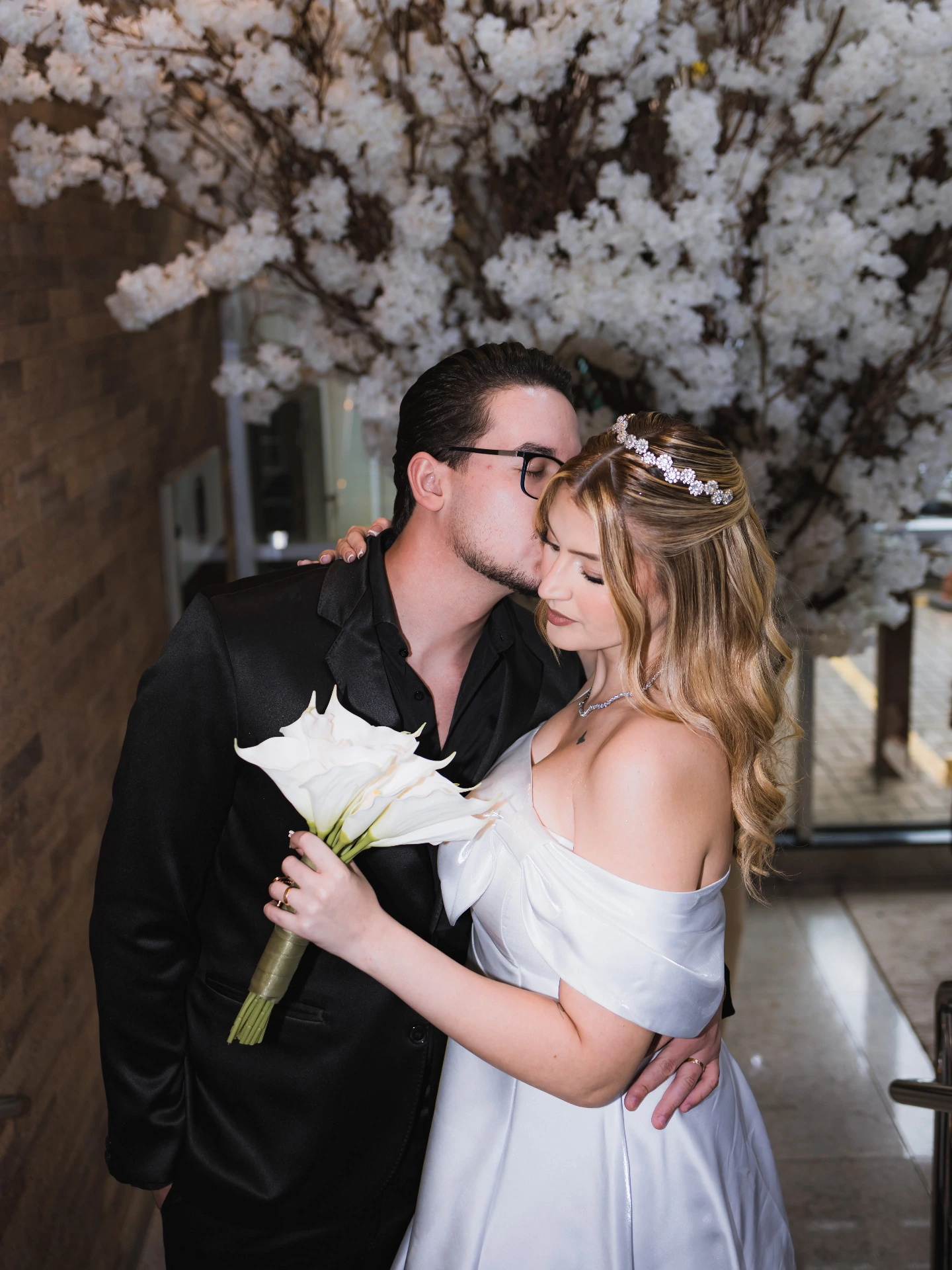 Os noivos se beijando durante o casamento civil, a noiva com o buquê