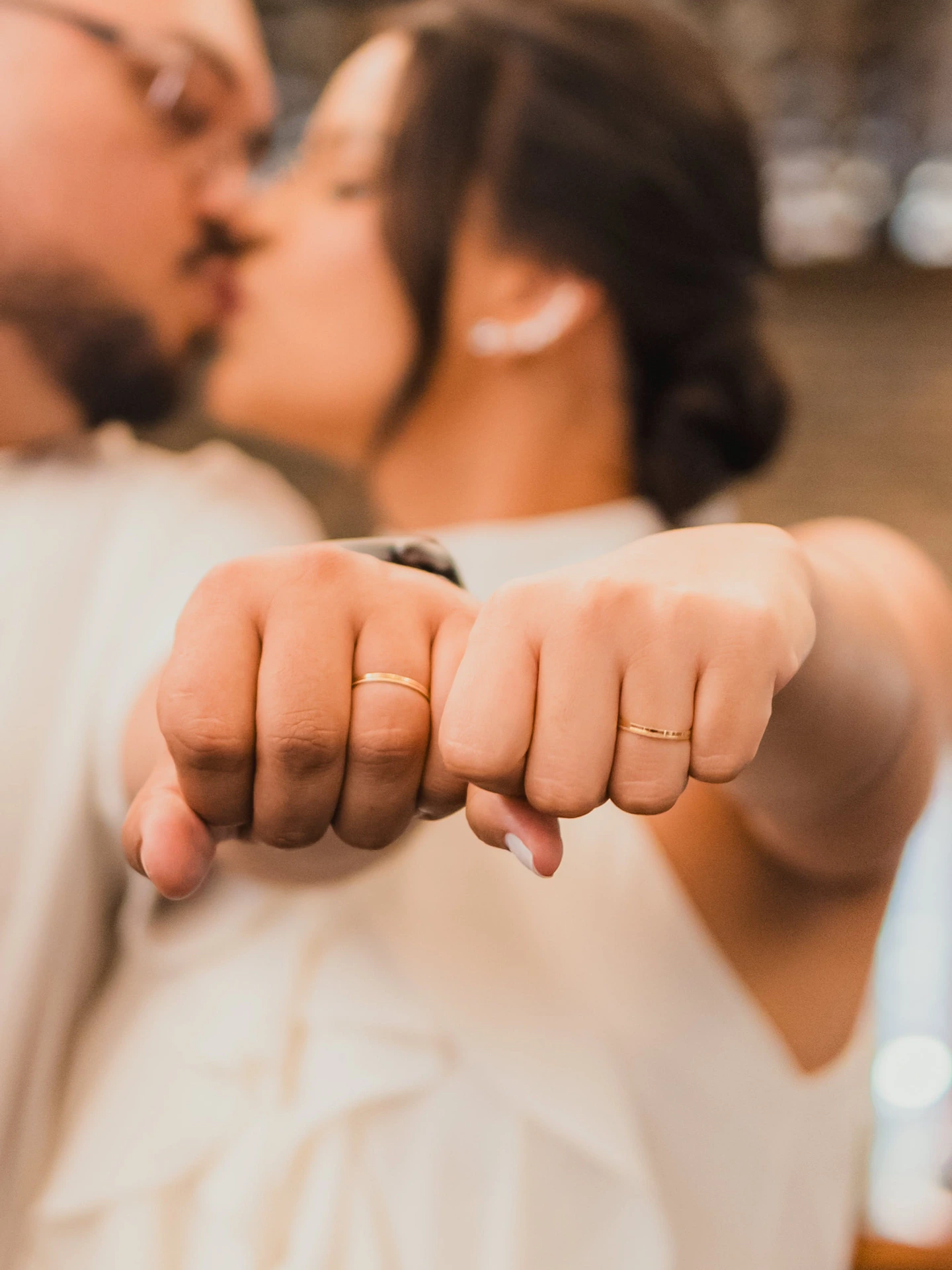 Os noivos se beijando e mostrando as alianças nas mãos