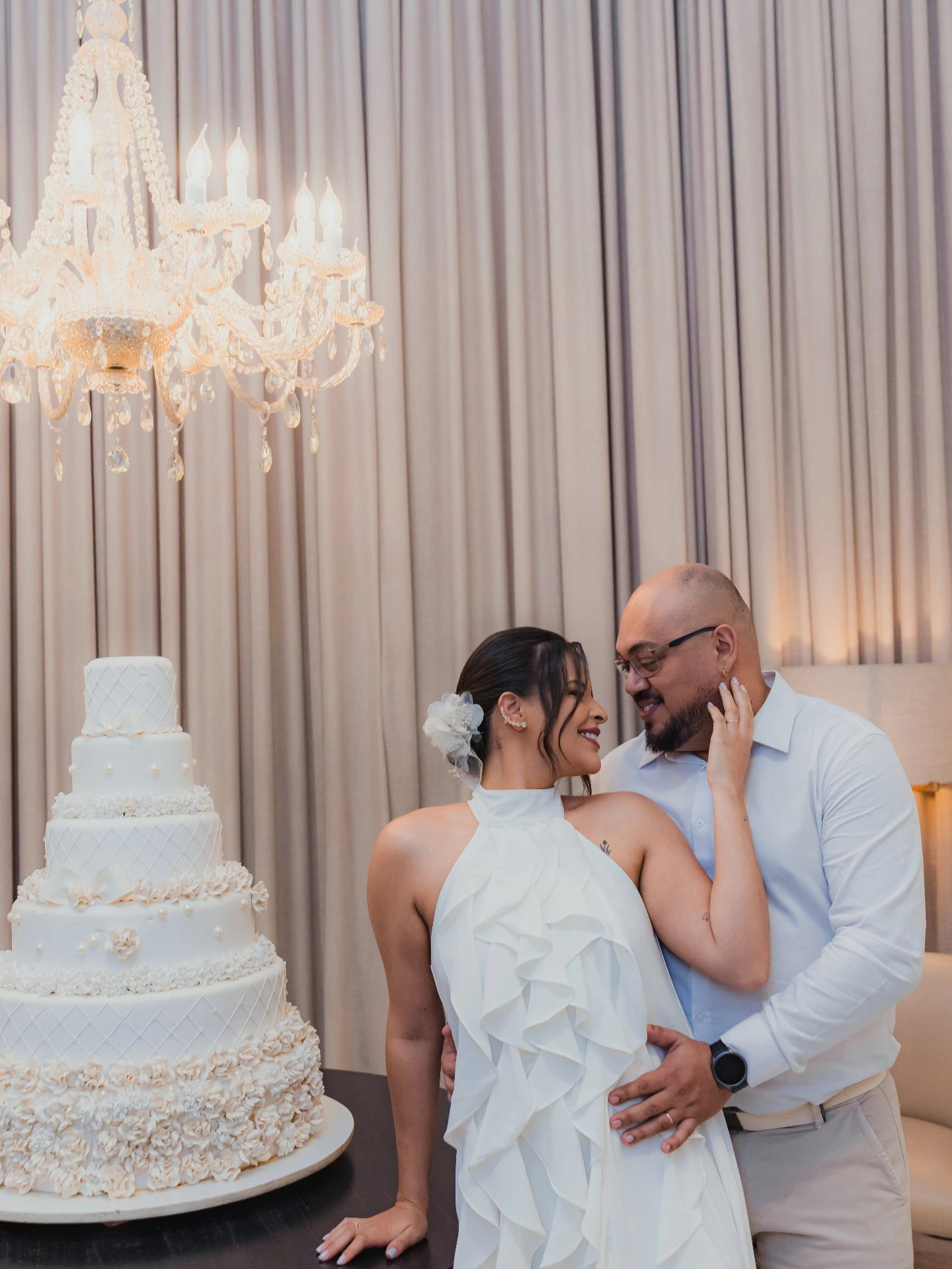 Jessica e Alex se beijando ao lado do bolo de casamento de vários andares