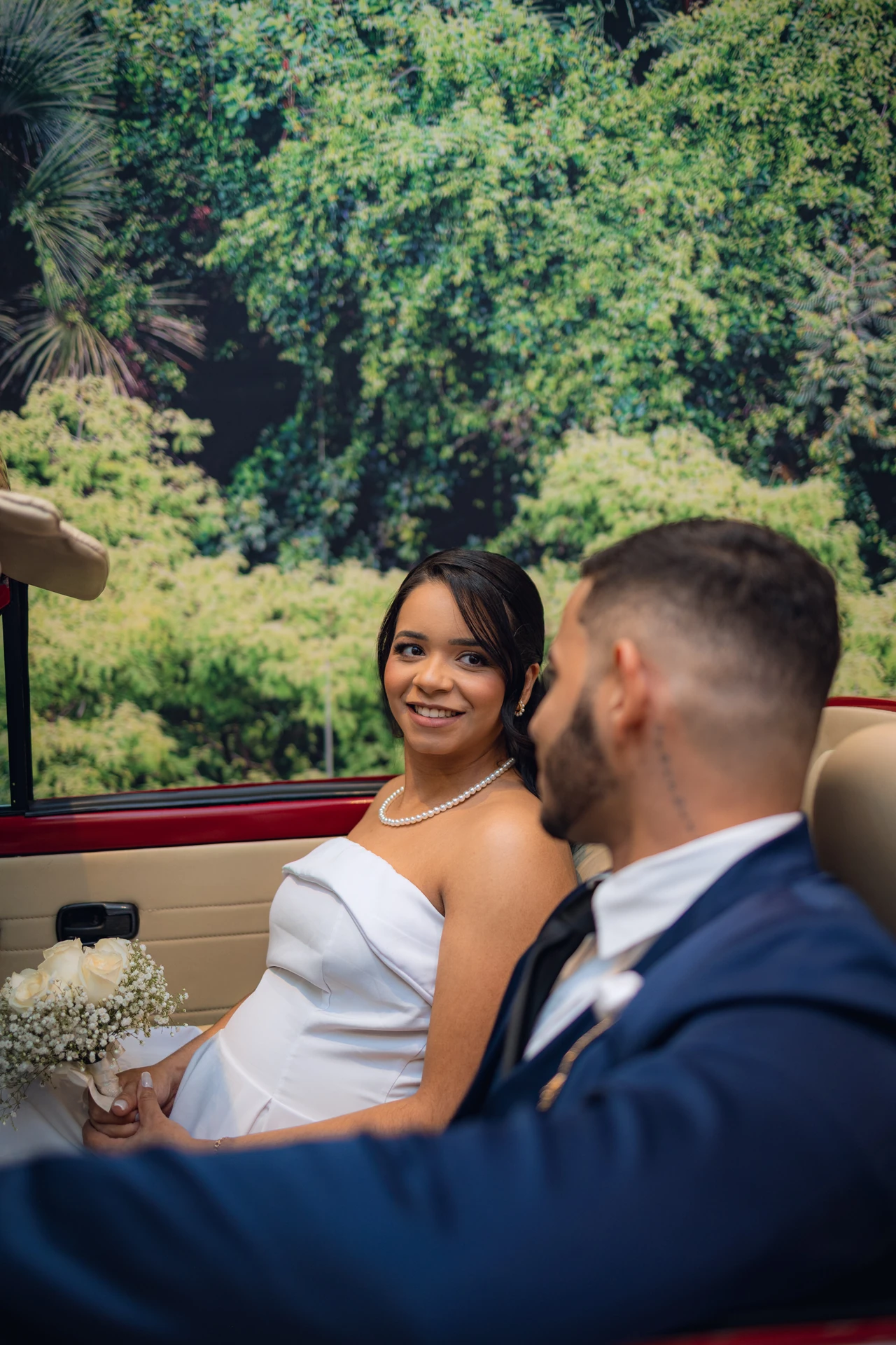 Jéssica e Thiago dentro do carro antigo vermelho, ela sorrindo para ele