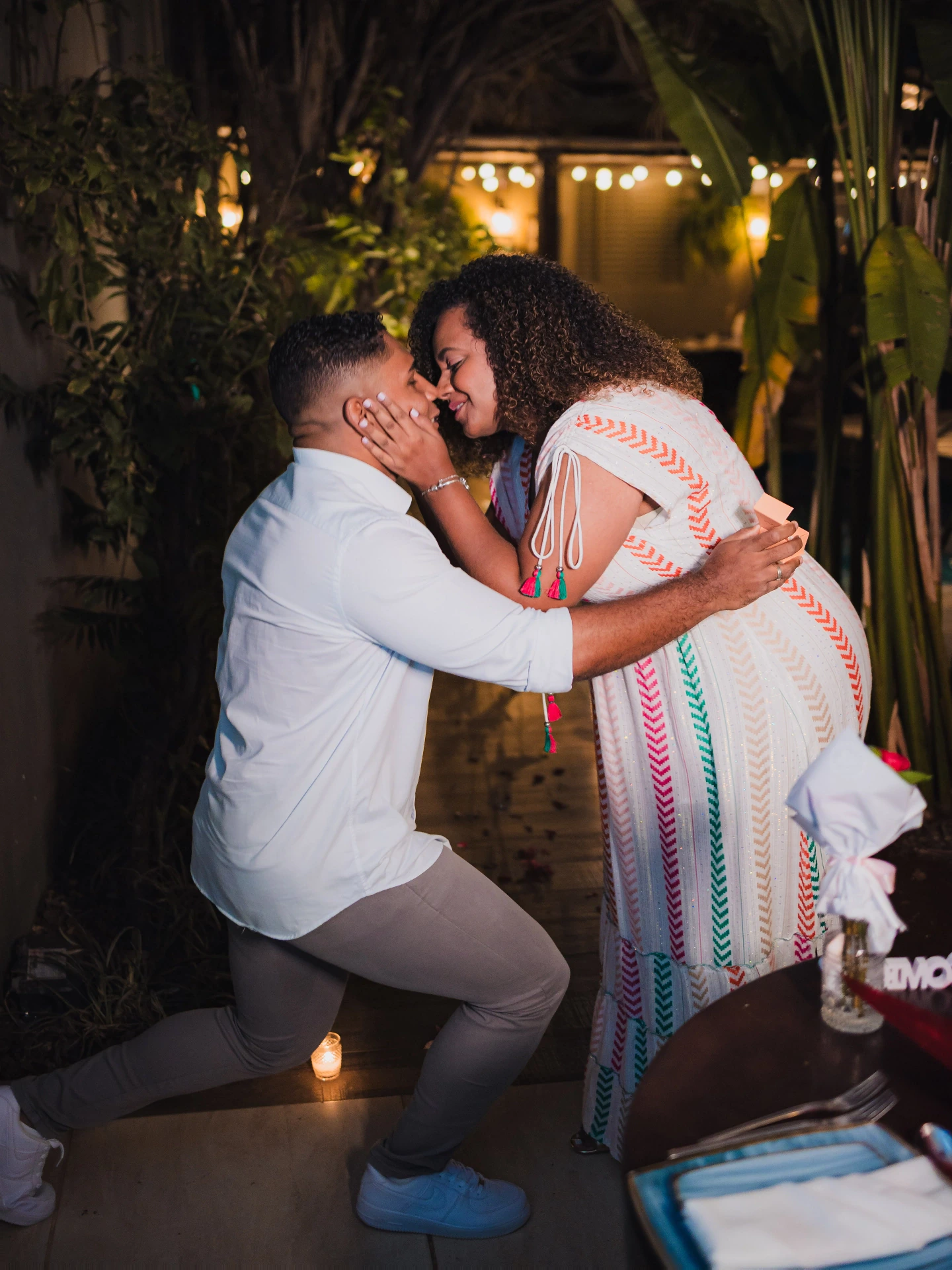Mulher abraçando o namorado ajoelhado no momento do pedido de casamento