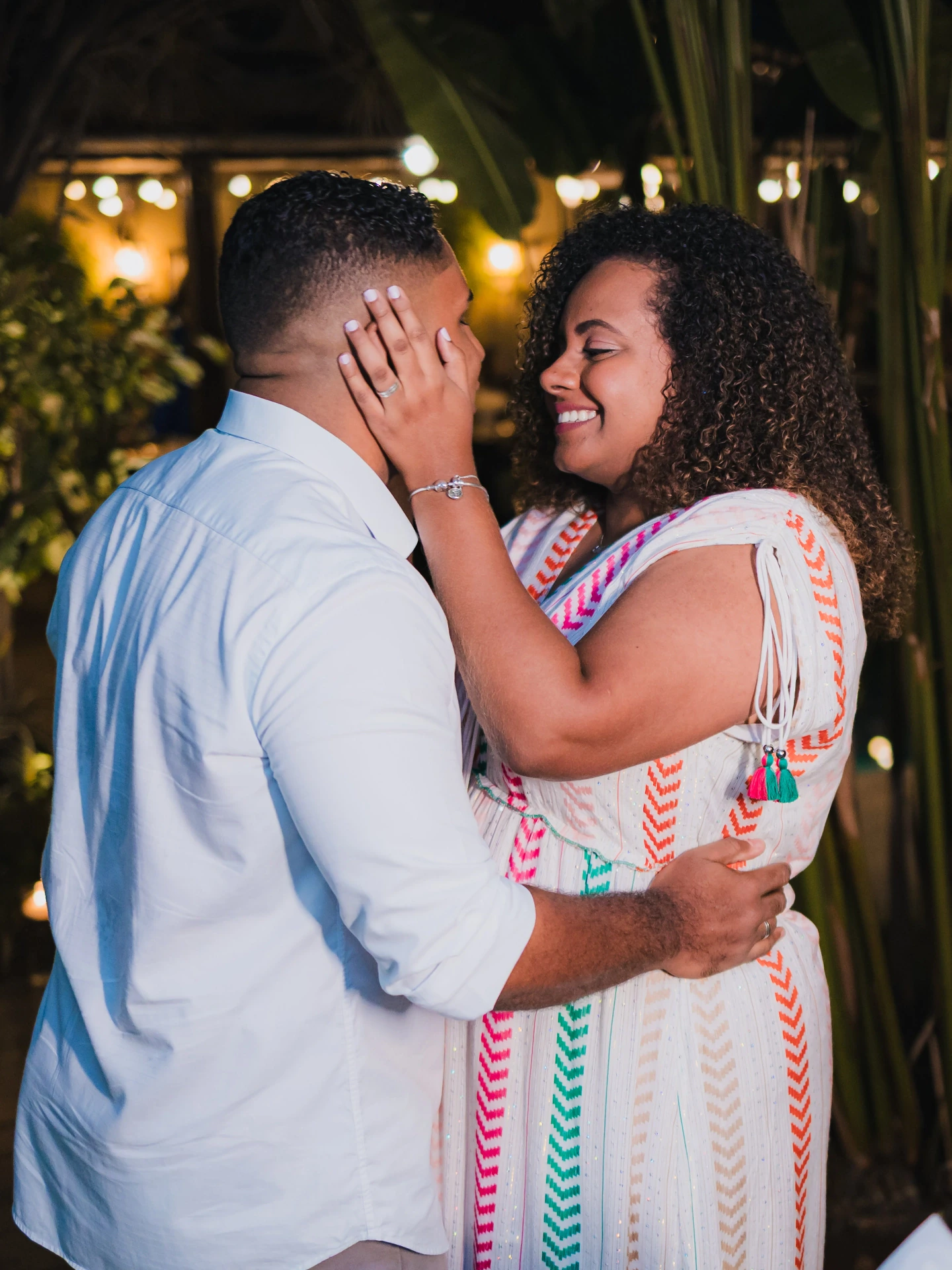 Casal quase se beijando, a mulher com a mão no rosto do namorado