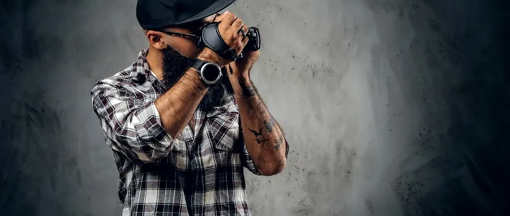 Fotógrafo registrando um evento de forma documental, com a câmera junto ao rosto