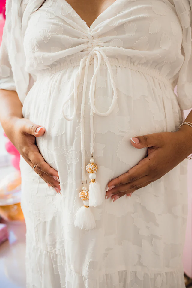 Detalhe de mãos na barriga de grávida em chá de bebê