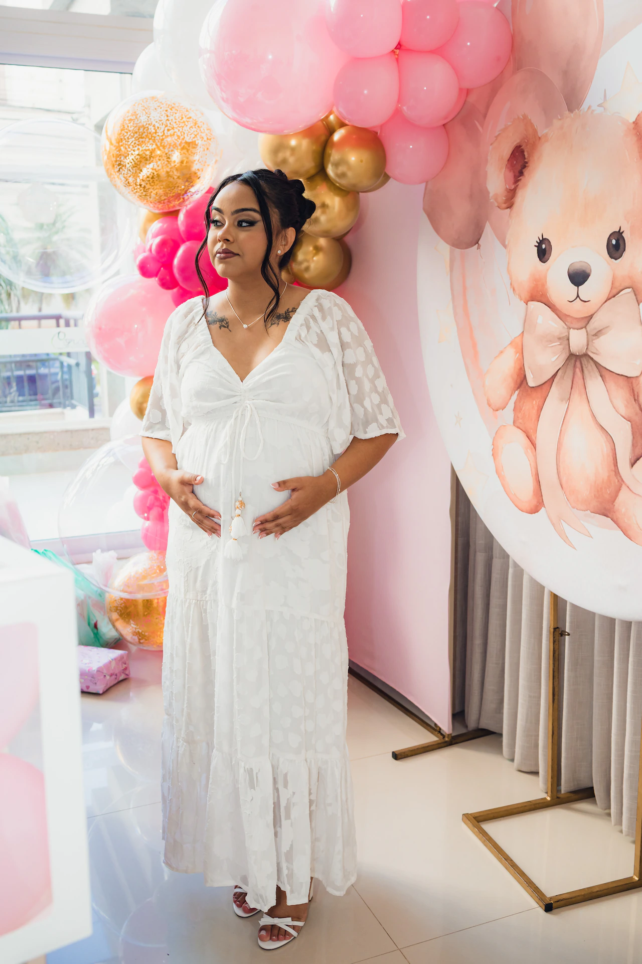 Detalhe do vestido branco da grávida no chá de bebê