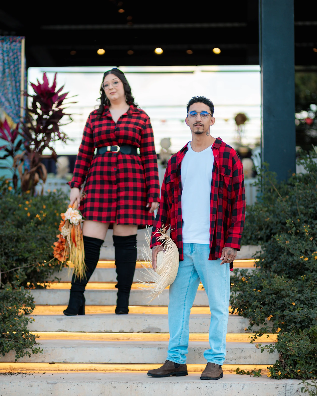 Casal em pé nos degraus do cenário de festa junina ao ar livre