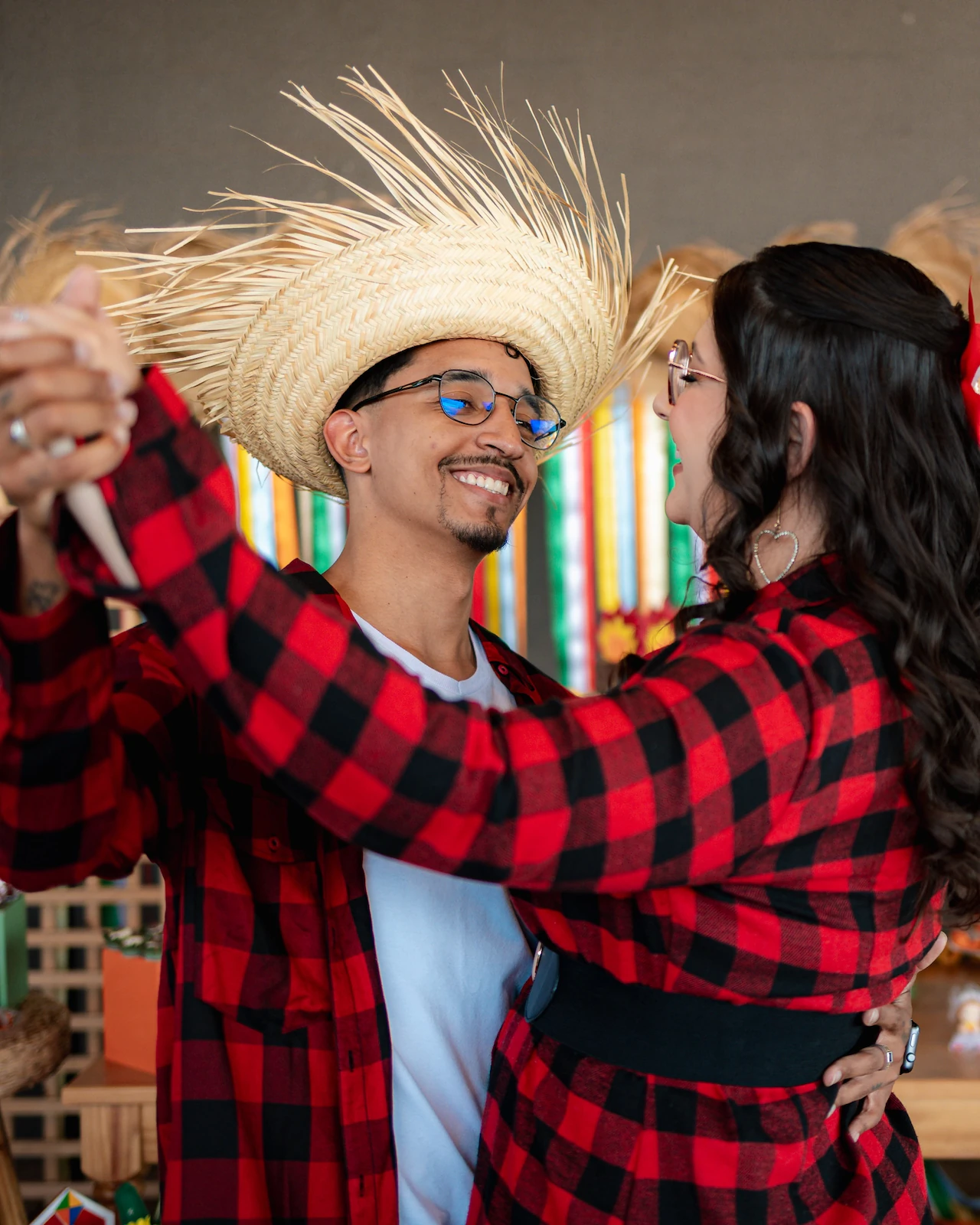 Casal dançando no ensaio de festa junina, o homem de chapéu de palha