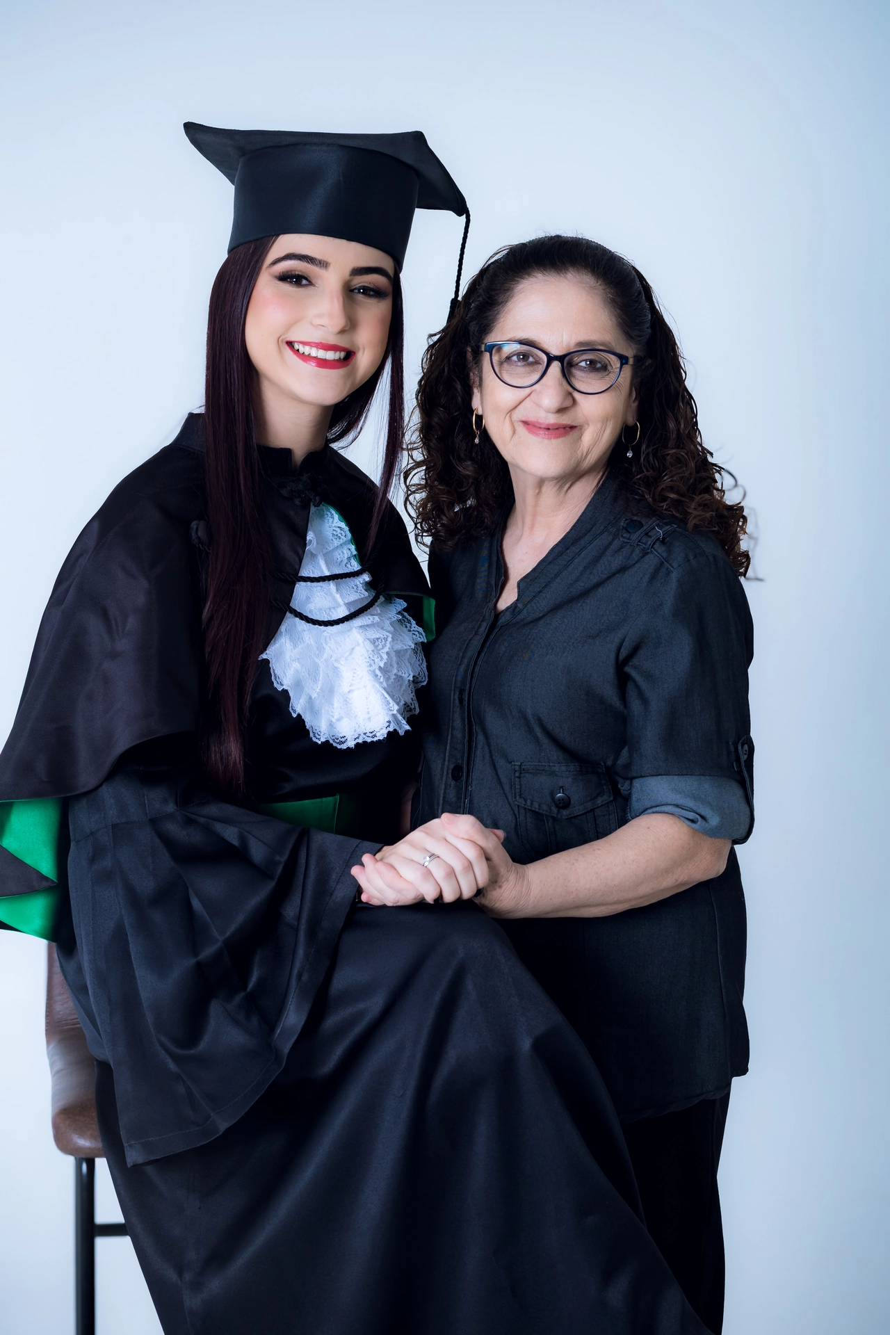 Formanda do ensino médio ao lado da mãe, retrato de ensaio de formatura em estúdio