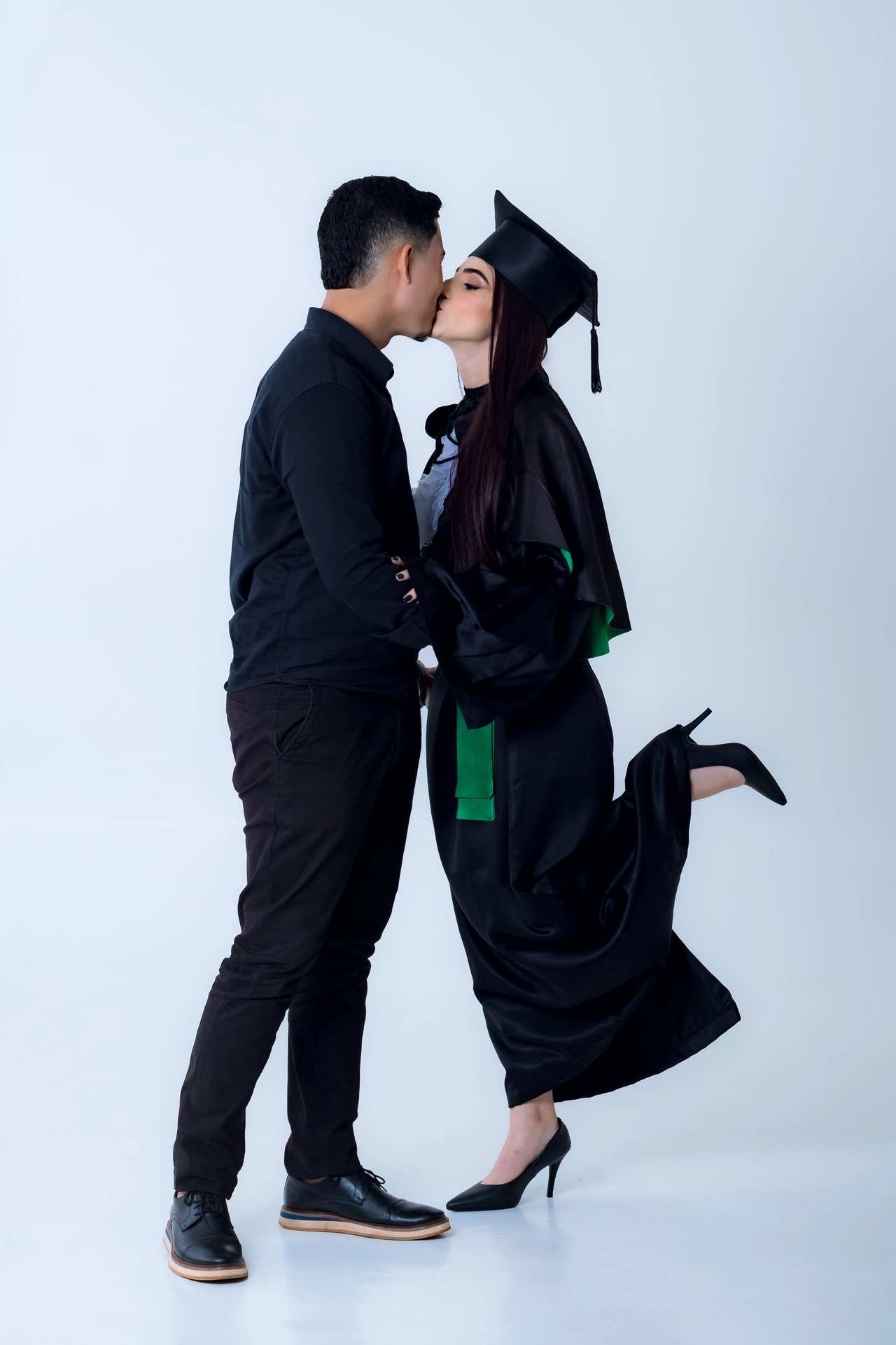 Formanda e namorado se beijando, ela com a perna erguida