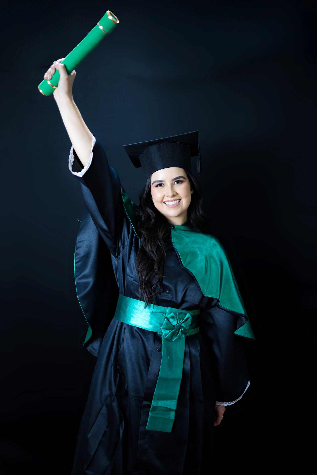 Formanda erguendo o canudo para o alto ao comemorar a formatura