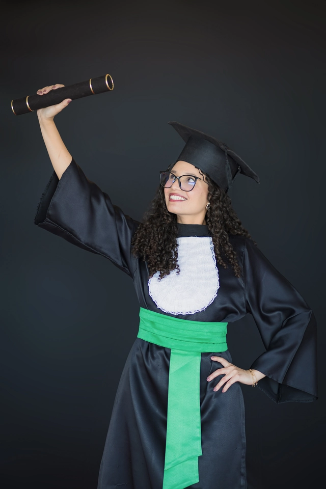 Formanda de Medicina Veterinária erguendo o diploma, retrato em estúdio